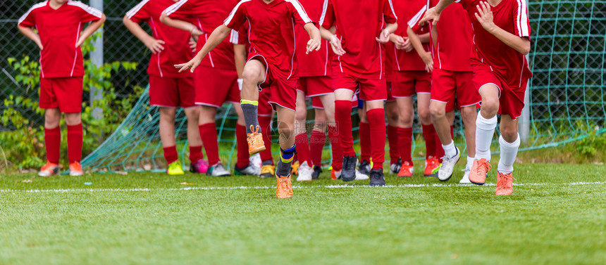 青年足球团体训练课伸展运动青少年足球运动员的柔韧练习足球比赛前图片