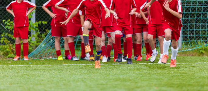 青年足球团体训练课伸展运动青少年足球运动员的柔韧练习足球比赛前图片