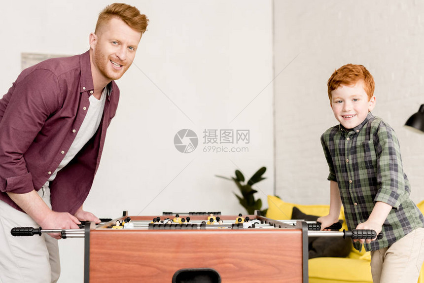 快乐的父亲和儿子在家里一起玩桌球时在相图片