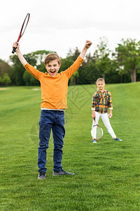 快乐的小孩拿着羽毛球打斗和胜利图片