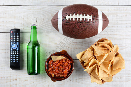 远程电视啤酒瓶沙尔萨薯片碗和美式足球图片