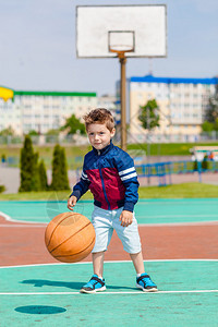 小男孩一个人在篮球场打球图片