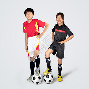 年幼的亚洲儿童在踢足球孤图片