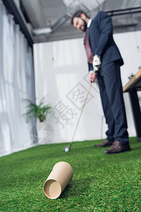 对在办公室打高尔夫球的年轻商人有背景图片