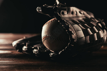 木桌上皮革棒球和手套的特写视图图片
