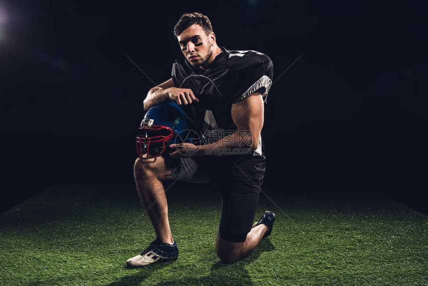 美国足球运动员单膝站在草地上图片
