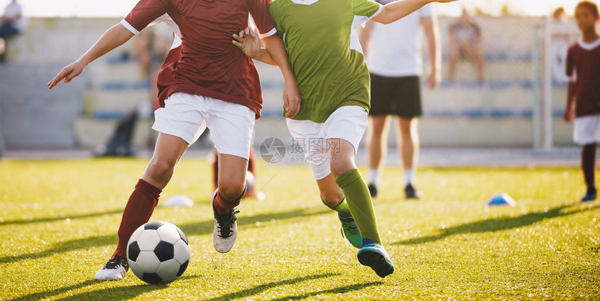 男孩踢足球运行足球员足球场上的孩子们带着球跑一群孩子踢足球比赛的图片