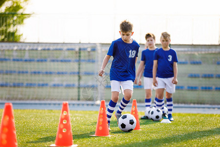 足球训练运球锥钻学校少年足球队的年轻男孩在草地上练习孩子们图片