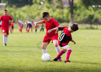 儿童足球幼儿球员在足球场上比赛图片