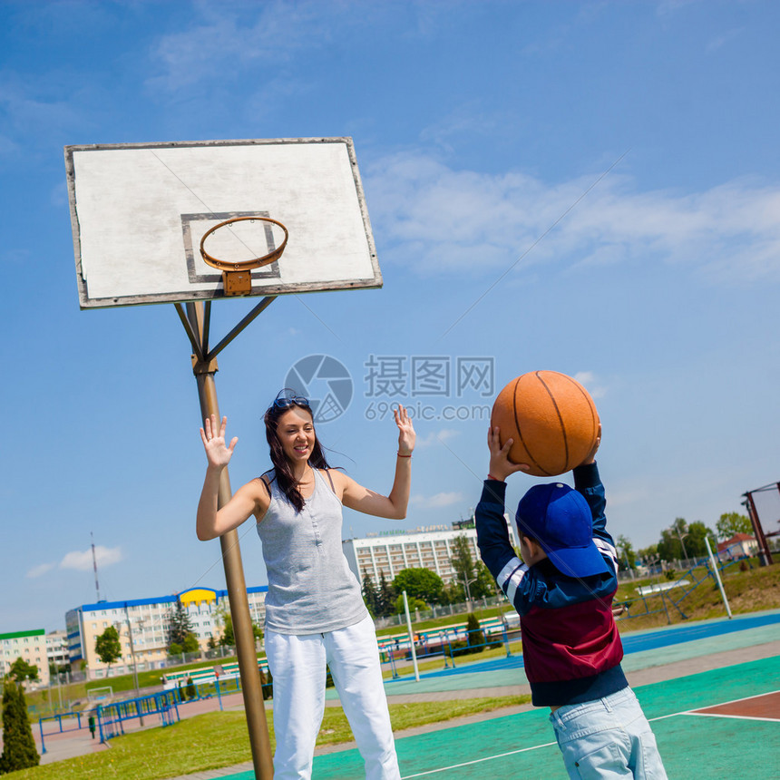 妈和小男孩儿子在篮球场打篮球图片