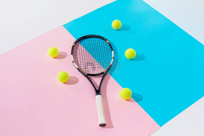 蓝色和粉色纸上的网球拍和黄色球图片