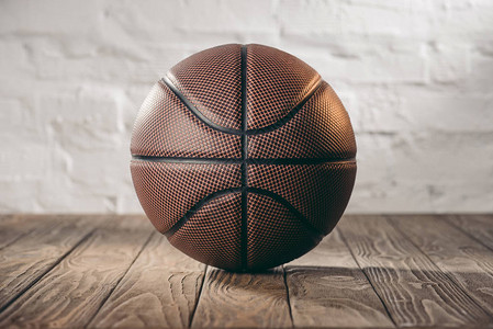 木地板上的棕色皮革篮球背景图片