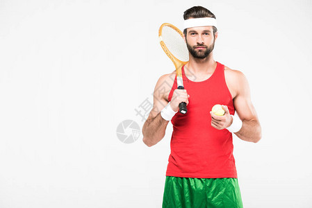 英俊的网球选手有前型木棍和球在图片
