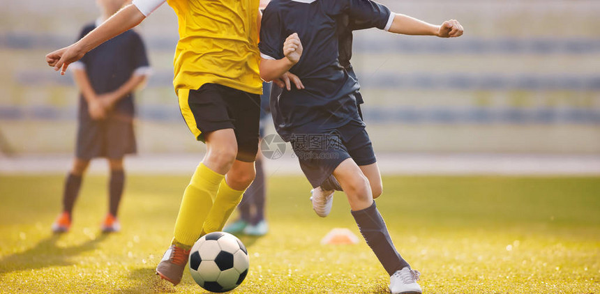 在体育场的足球比赛足球员在夏日阳光下比赛年轻的足球男孩在图片