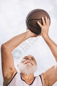 手拿着篮球的长胡子老人低角度视图图片