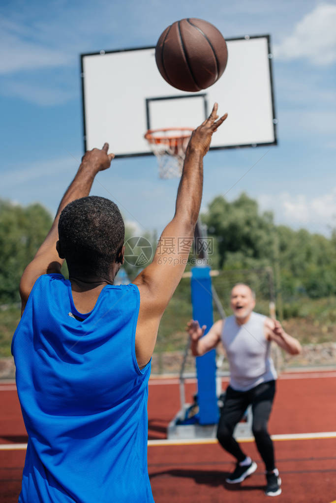 多种族老年男子在夏季日操场一起打篮球图片