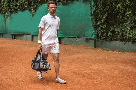 网球场培训后英俊的网球运动员在网球场图片