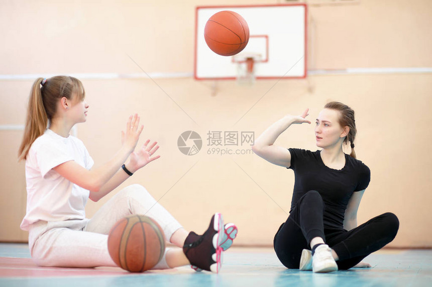 在健身房打篮球的女孩年轻学生图片