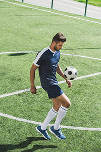 足球运动员在足球场训练中踢球图片
