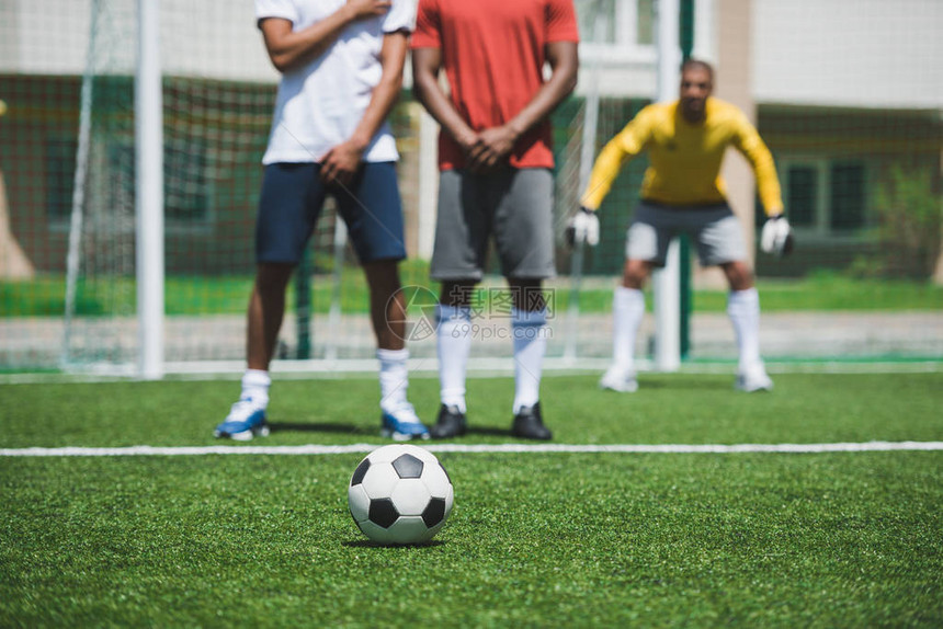 足球赛时一组足球员在球场上踢足球比赛图片