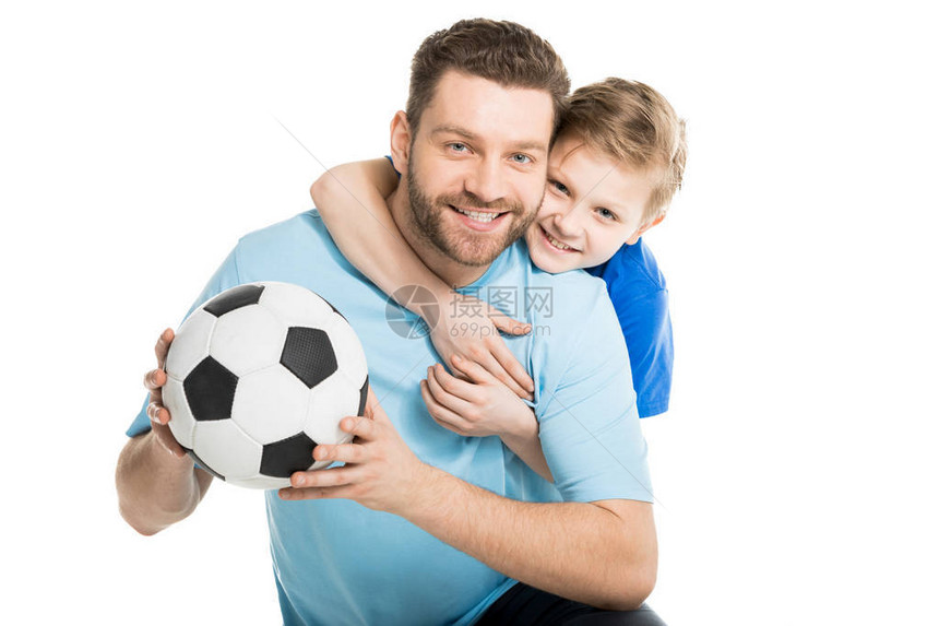 年幼的父亲和儿子冒着足球在图片