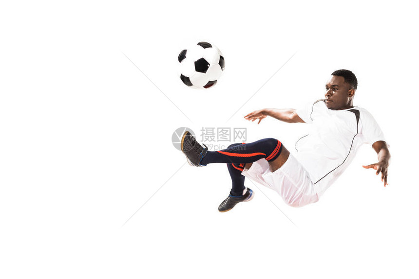 美国足球运动员踢球跳着孤立的白图片