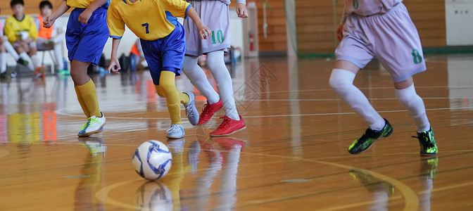 室内足球场追逐 亚洲女孩团队学生孩子的足球游戏图片