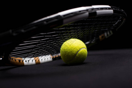 用黑色隔开的网球和拍的特写视图背景图片