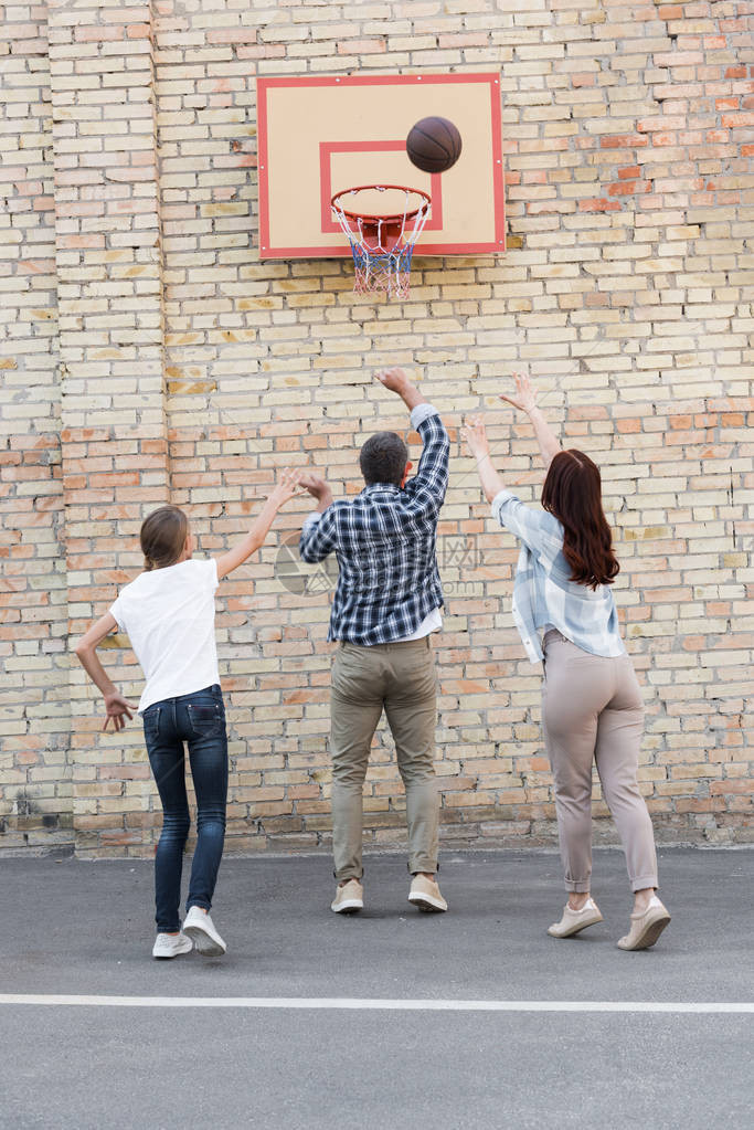 一家人在操场上一起打篮球的背影图片