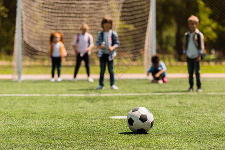站在草地上和小孩后边的足球近图片