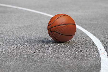 位于沥青地板上的孤立橙色篮球在庭外法庭背景图片