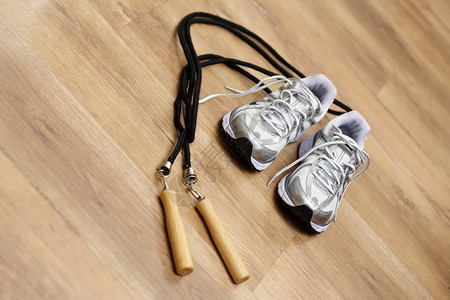 在健身房地板上跳绳和训练师作为健身概念图片