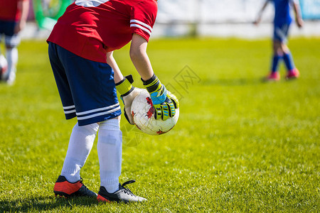 青年足球守门员接球足球比赛孩子们在球场图片