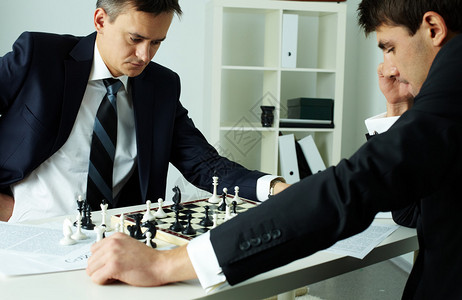 两个商人下棋时看着棋盘的形象图片