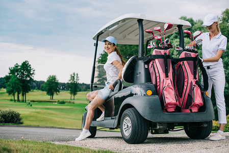 高尔夫球车上微笑的女高尔夫球手准备在高图片