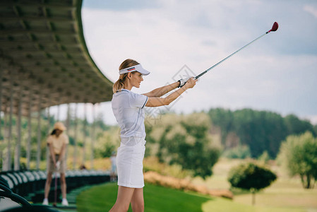 女高尔夫球手在马球和高尔夫球场打高尔夫球背景图片