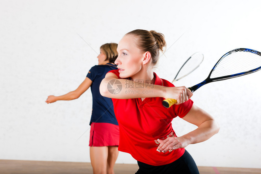 两个女子在健身场打壁球做体育比赛可图片