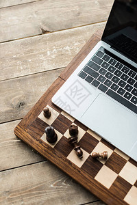 用象棋和笔记本电脑在锈木表面的象棋图片
