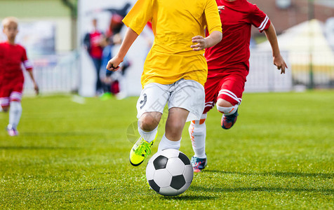 运行青年足球员男孩踢足球比赛追逐球的儿童足球员图片