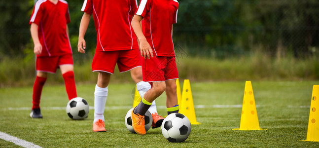 孩子们的足球训练营孩子们用球和锥体训练足球技巧足球激流回旋训练以提高背景图片