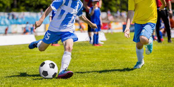 运行青年足球员男孩踢足球比赛追逐球的儿童足球员图片