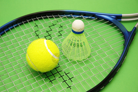 绿色背景中的网球羽毛球和拍图片