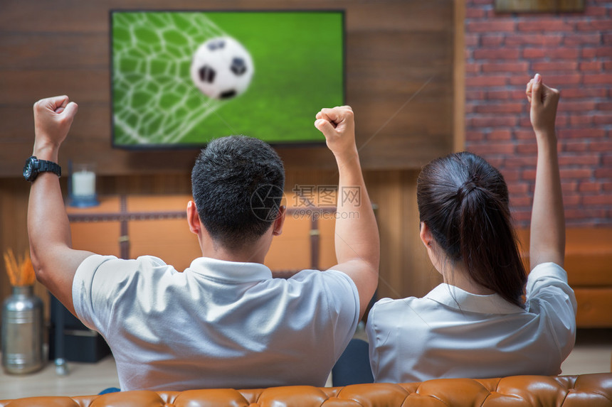 亚洲夫妇在看足球比赛时玩得很开心图片