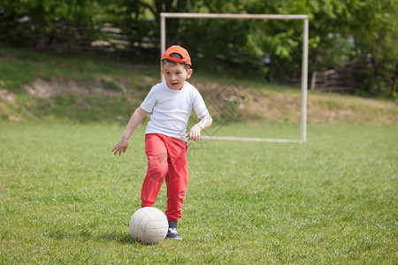 小男孩在公园里踢球图片
