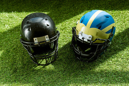 美国足球在绿草地上安全头盔的背景图片