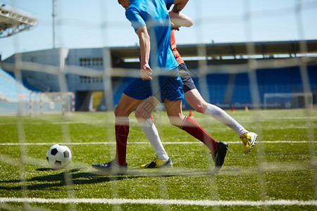 运动员在绿地上踢足球图片