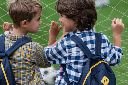 两个小男生站在足球门旁互相看对方的后视图片