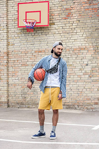 时尚的年轻人篮球站在图片