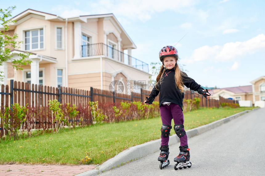 身戴头盔和防护复制空间的街上活跃少女滑溜冰全长肖像图片