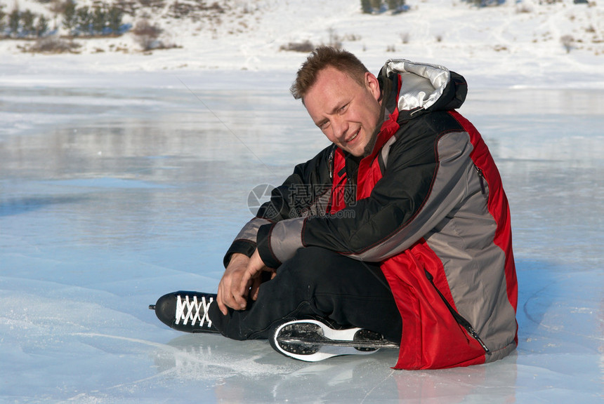 骑冰鞋后在冰上休息的人图片